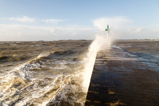 Jet&eacute;e avec phare vert dans la temp&ecirc;te sous un ciel bleu. Pointe de Merquel, Mesquer