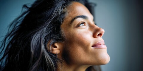 A portrait of a woman with a gentle expression, gazing upwards towards the light.