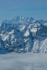 Obraz premium Dramatic Rocky Mountain Peaks Rising Above Misty Cloud Layer in Swiss Alps