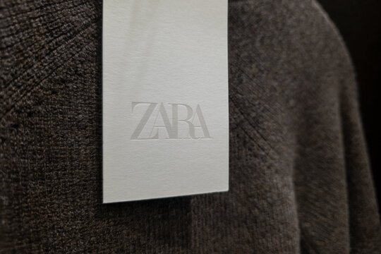 WARSAW, POLAND - JANUARY 21, 2026: A brown ribbed knit sweater hanging on a black hanger branded with the Zara logo, featuring a white price tag in a fashion retail store