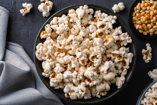 Delicious popcorn in bowl on black  stone table background.

