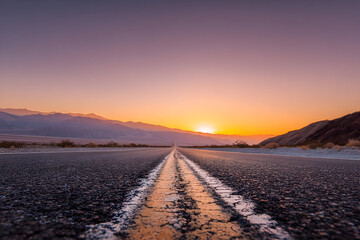 Obraz premium Serene desert road at sunset with mountains in the distance