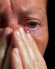 Naklejka premium Close-Up of a Tearful Face with Hand Over Eyes Reflecting Deep Emotion and Vulnerability