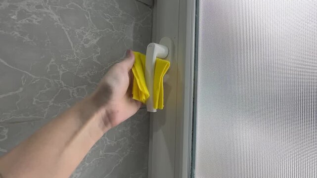 Female hands disinfect and wipe window handle with sanitizer closeup