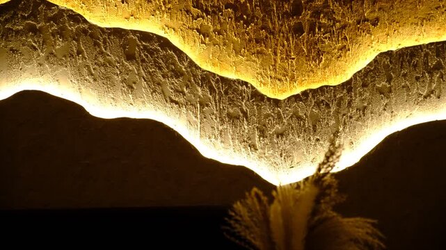 Modern apartment with three-layer wall , multilayer textured polymer mineral plaster, Abstract wavy curve  panel wall, installed with hidden glowing led, provides illumination for fashion interior