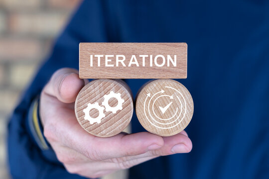 Person holding wooden blocks with icons sees the text ITERATION. Iteration Process Agile Cycle Development Operations Technology. Business planning and time to iteration 4 concept.