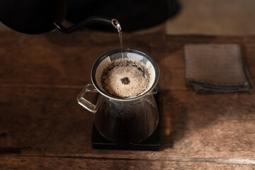 Barista pouring water on coffee ground with filter. Alternative ways of brewing coffee. Coffee shop...