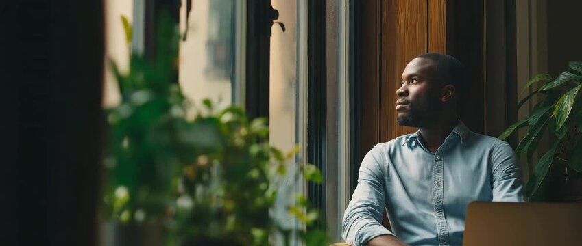Person taking short pause from work, looking out window, calm reset moment, work-life balance

