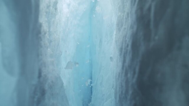 Camera Movement Through an Ice Crevasse with Falling Pieces of Ice . Slow Motion
