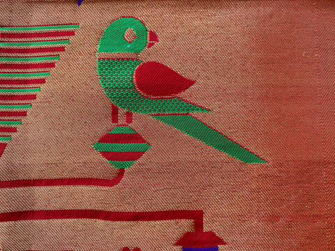 A close-up view of a pure silk Paithani saree, showcasing intricate parrot motifs and luxurious traditional Zari weaving.