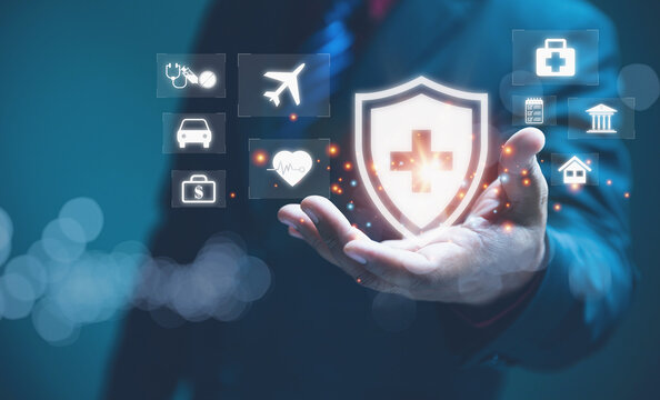 Comprehensive Insurance and Global Healthcare Protection Concept. A businessman in a suit holding shield with a medical cross, protective services including health insurance, and property assurance.