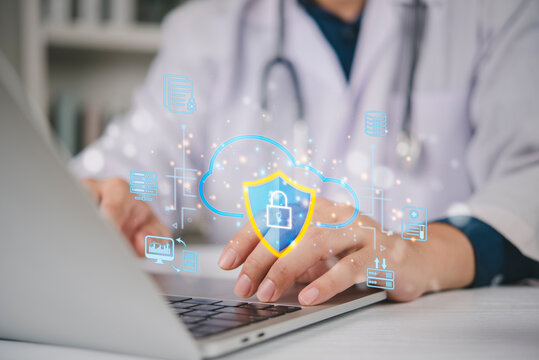 Doctor using laptop with cloud security shield hologram. Medical data protection, electronic health records EHR privacy, and HIPAA compliance. Healthcare cybersecurity technology against ransomware.