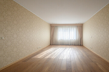 Obraz premium Spacious empty room with wooden flooring, beige patterned wallpaper, large window with sheer white curtains and side drapes, recessed ceiling lights, neutral decor.