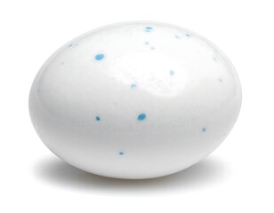 A close-up studio shot shows a single, egg-shaped candy with a glossy, white exterior and small, blue speckled details. Its shadow is visible
