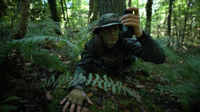 Soldier in camouflage gear crawling through dense forest looking through monocular. Soft natural light, tactical atmosphere.
