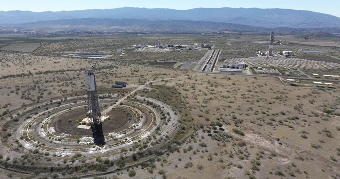 Wide drone shot over Solar Almeria mirror field and solar tower showing renewable energy research infrastructure in arid Spain