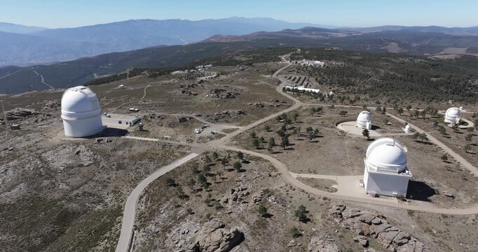 Drone view facing toward Calar Alto Observatory dome on rocky mountain plateau in Spain with expansive highland landscape