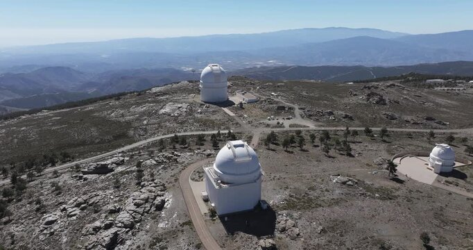 Calar Alto Observatory Spain aerial close view of telescope dome and access road on rocky plateau with sweeping mountain horizon