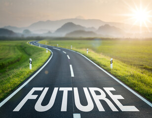 Naklejka premium Long winding road leads toward distant mountains with the word future painted on the pavement during morning light