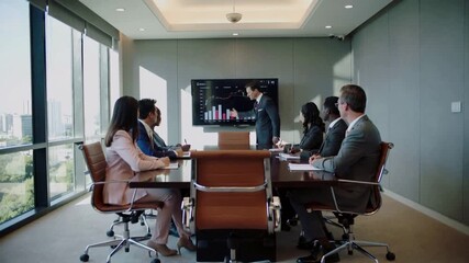 Corporate executive presenting financial growth charts to diverse business team in modern boardroom. Backward camera movement revealing meeting participants. - Powered by Adobe