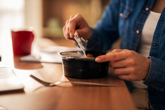 Woman opening meal container for a quick lunch