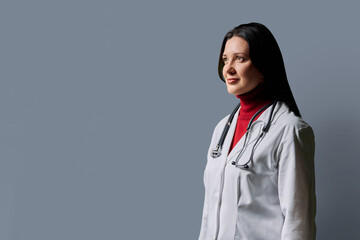 Profile portrait of middle-aged woman doctor on grey studio background © Valerii Honcharuk