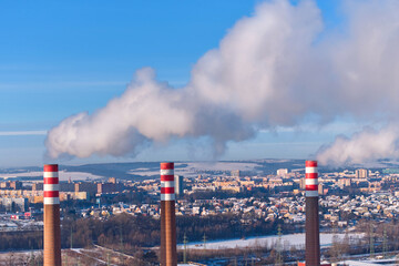 Industrial power plant with red and white smokestacks releasing steam above an urban skyline, representing electricity generation, energy infrastructure, and heavy industry. Ideal for: energy sector.
