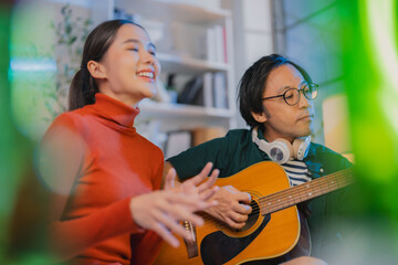 alented Asian musician and singer host a live stream concert from home at night, using a ring light for a professional online broadcast and influencer experience