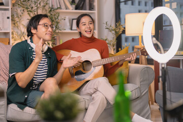alented Asian musician and singer host a live stream concert from home at night, using a ring light for a professional online broadcast and influencer experience