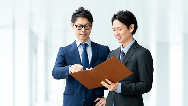 書類を確認しながら打ち合わせをする日本人ビジネスマン, Japanese businessmen reviewing documents during a meeting