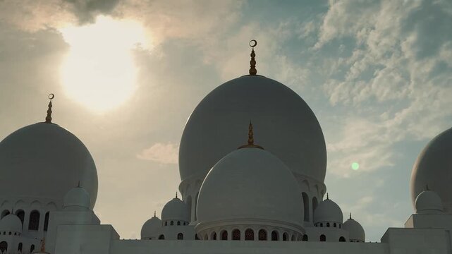 A majestic view of the Sheikh Zayed Grand Mosque in Abu Dhabi. This clip showcases the stunning Islamic architecture, white marble domes, and floral courtyard at sunset.

