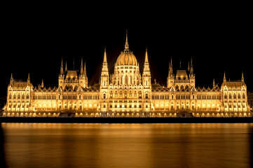 Fototapeta premium Illuminated Hungarian Parliament Building at night with Danube river reflections in Budapest, Hungary