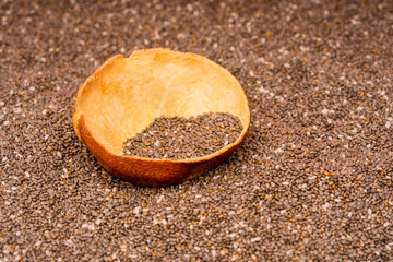 Chia seeds in a wooden bowl with a wooden spoon