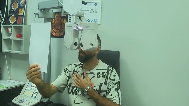 Man checks his vision using eye exam equipment in a clinic