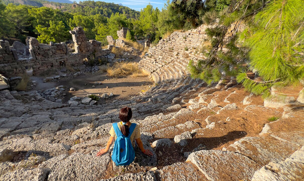 A tourist visits the ancient Roman theater in Phaselis, Turkey, an impressive testament to the architectural achievements of antiquity.