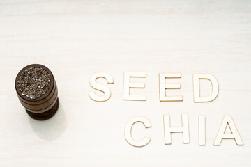 Chia seeds in a wooden bowl with a wooden spoon