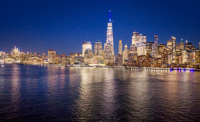 Obraz premium New York City at night. NYC skyline night view. NewYork cityscape waterfront. Manhattan night view. New York panoramic. NYC cityscape. New York night skyline. New York City aerial view of Manhattan.
