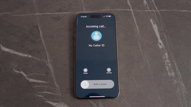 A smartphone rests on a table, displaying an incoming call from No Caller ID. The call alerts the user to a hidden caller trying to reach them.