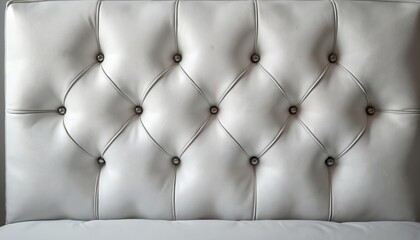 Fototapeta premium White leather headboard with diamond tufting and silver nailhead trim. This textured upholstery offers a classic look for bed or sofa. Adds comfort and style to bedroom or living space.