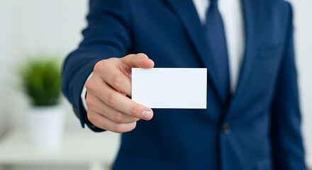 Fototapeta premium Person in blue suit holding blank white business card hand