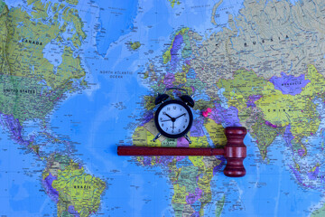 Red gavel and black stopwatch on world map symbolize global justice, legal urgency, and international decision-making across geographic boundaries.