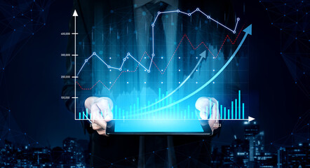 A business professional stands in a dark cityscape, holding a tablet displaying vibrant digital graphs and charts that highlight financial growth and data trends. Scalp