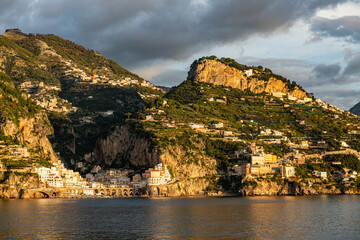 Pastel villages tumble down Amalfi's sheer cliffs like sun-kissed confetti, their terraced lemon groves and ochre tiles aglow in the amber hush of twilight