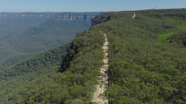 Drone aerial footage of Kedumba Valley Road located in a large forest in Jamison Valley in the Blue Mountains in New South Wales, Australia.