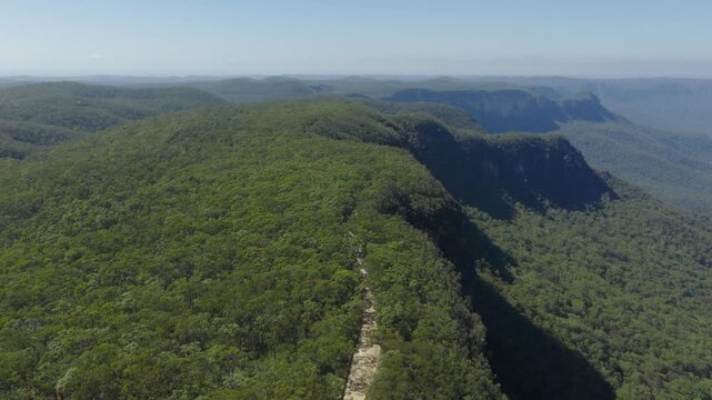 Drone aerial footage of Kedumba Valley Road located in a large forest in Jamison Valley in the Blue Mountains in New South Wales, Australia.