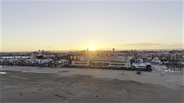 Valencia, Spain beach at sunset HDR drone video zooming out. Aerial view of Malvarrosa beach along Spanish coast along the Mediterranean.