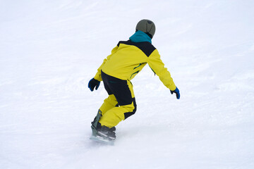 Naklejka premium Snowboarding. A lone figure of a snowboarder descending a snowy slope.