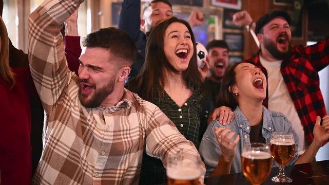 Excited friends celebrating a football match goal in a pub