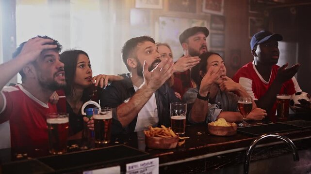 Disappointed sports fans reacting negatively after a loss in a bar
