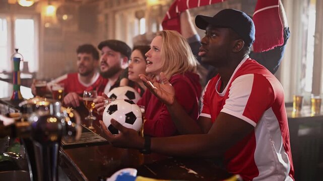 Disappointed soccer fans reacting to a lost match in a bar